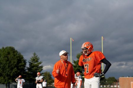 football coach and player talking on the field